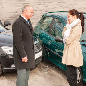 Man and women talking after car collision 