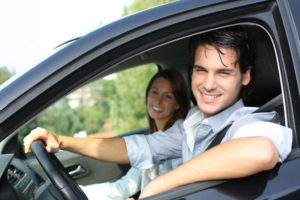 Couple cheerfully driving at the wheel